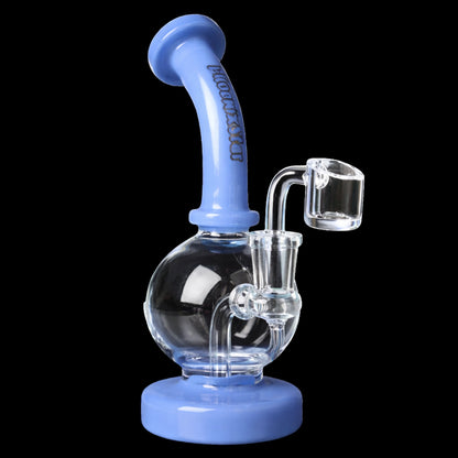 Three-quarter view of the Green Flower Phoenix Star 7 Inch Shorty Ball Rig With Insert Perc showing a blue curved mouthpiece, clear glass ball chamber and attached quartz banger against a black background