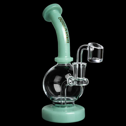 Angled close-up of the Green Flower Phoenix Star 7 Inch Shorty Ball Rig With Insert Perc showing a mint green curved mouthpiece and base with a clear spherical chamber and quartz banger against a black background
