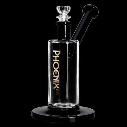 Close-up front view of the Green Flower Phoenix Star 7 Inch Bubbler Rig showing its clear cylindrical body, black angled mouthpiece, and gold vertical logo against a black background