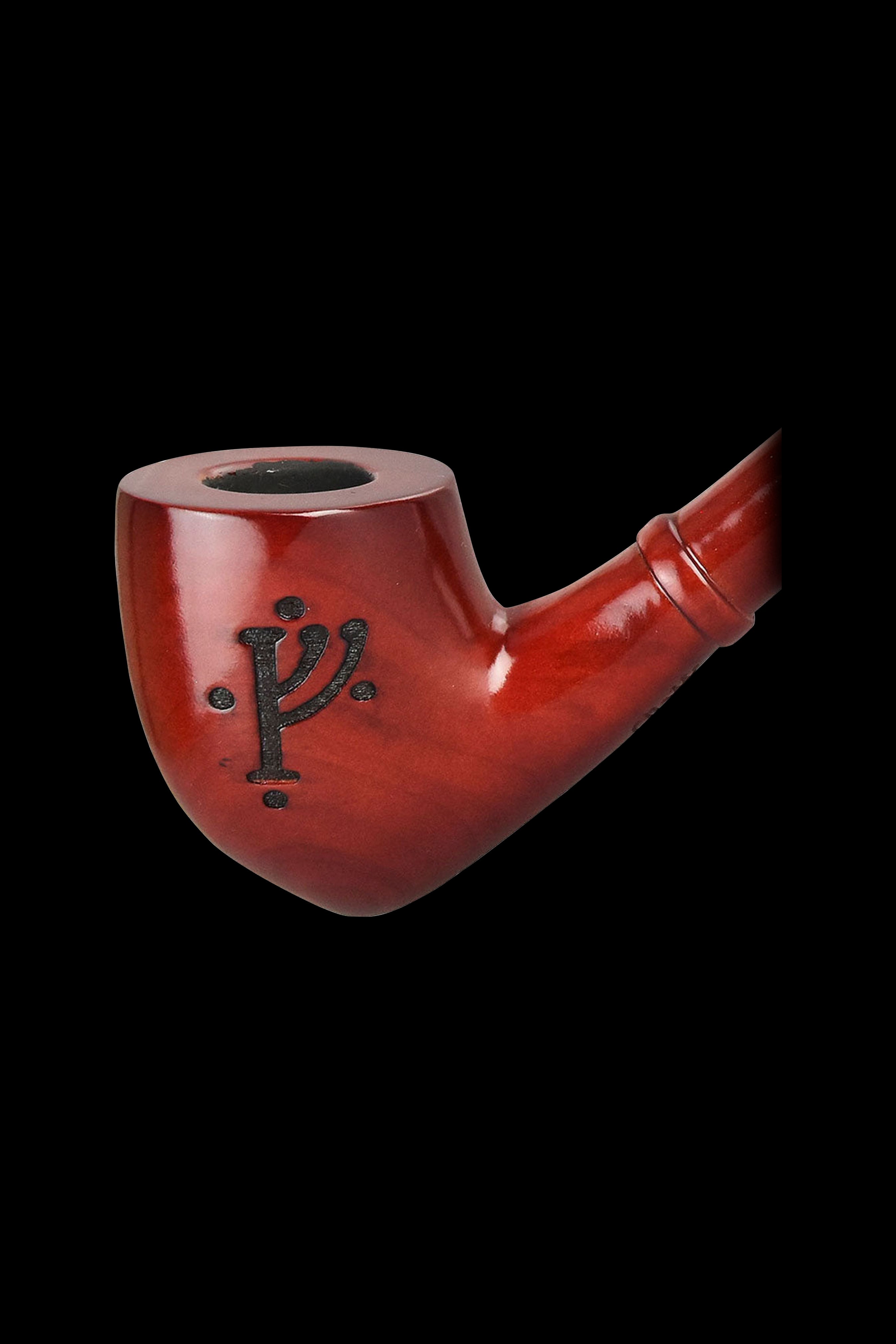 Red wooden pipe with carved symbol against a black background.