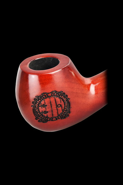 Red glass pipe with a decorative etching resembling The Shire from *Lord of the Rings*.