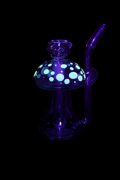 Purple glass mushroom-shaped dab rig with teal polka dots, isolated on a black background.