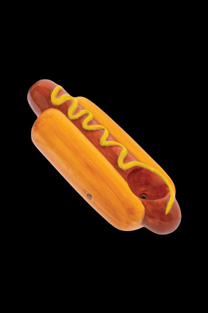 Glass pipe shaped like a hot dog with yellow “mustard” swirls.