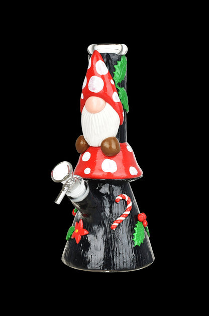 A festive glass bong shaped like a Christmas gnome, adorned with polka dots, a white beard, and holiday decorations against a black background.