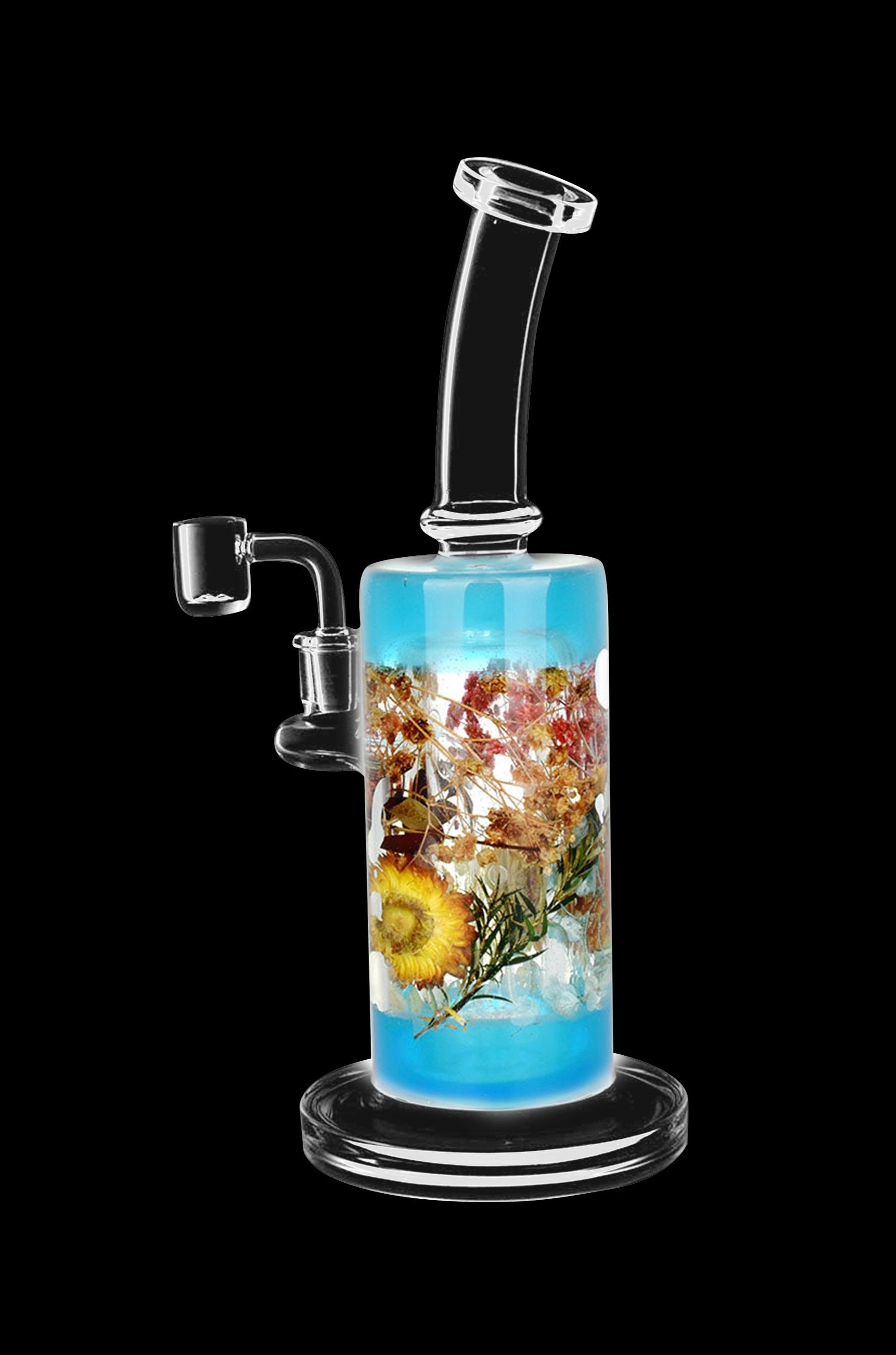 Glass water pipe (rig) with colorful botanical inclusions, isolated on a black background.