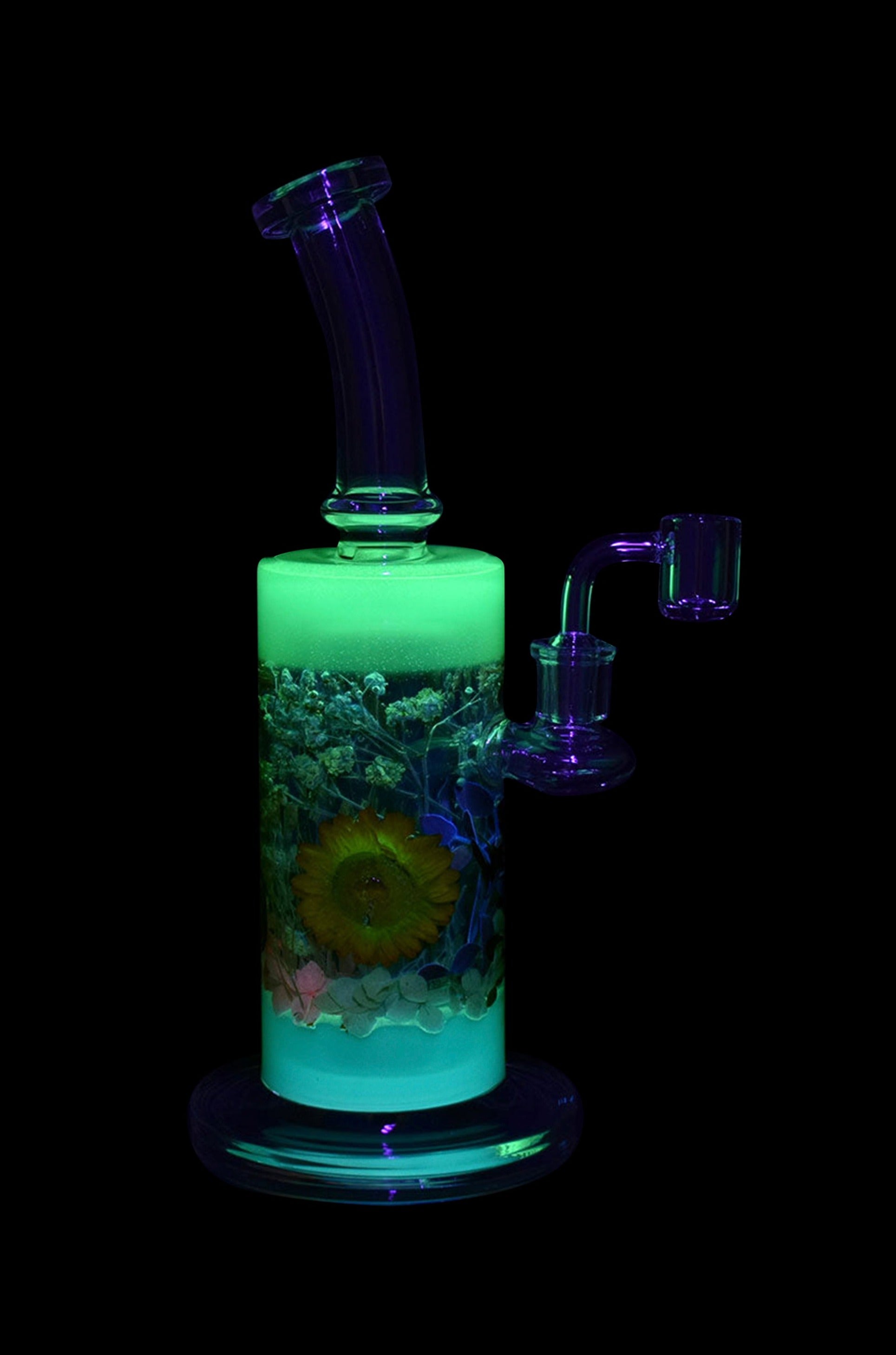 Glow-in-the-dark glass water pipe (bong) with preserved flowers encased within, and a quartz nail attachment.