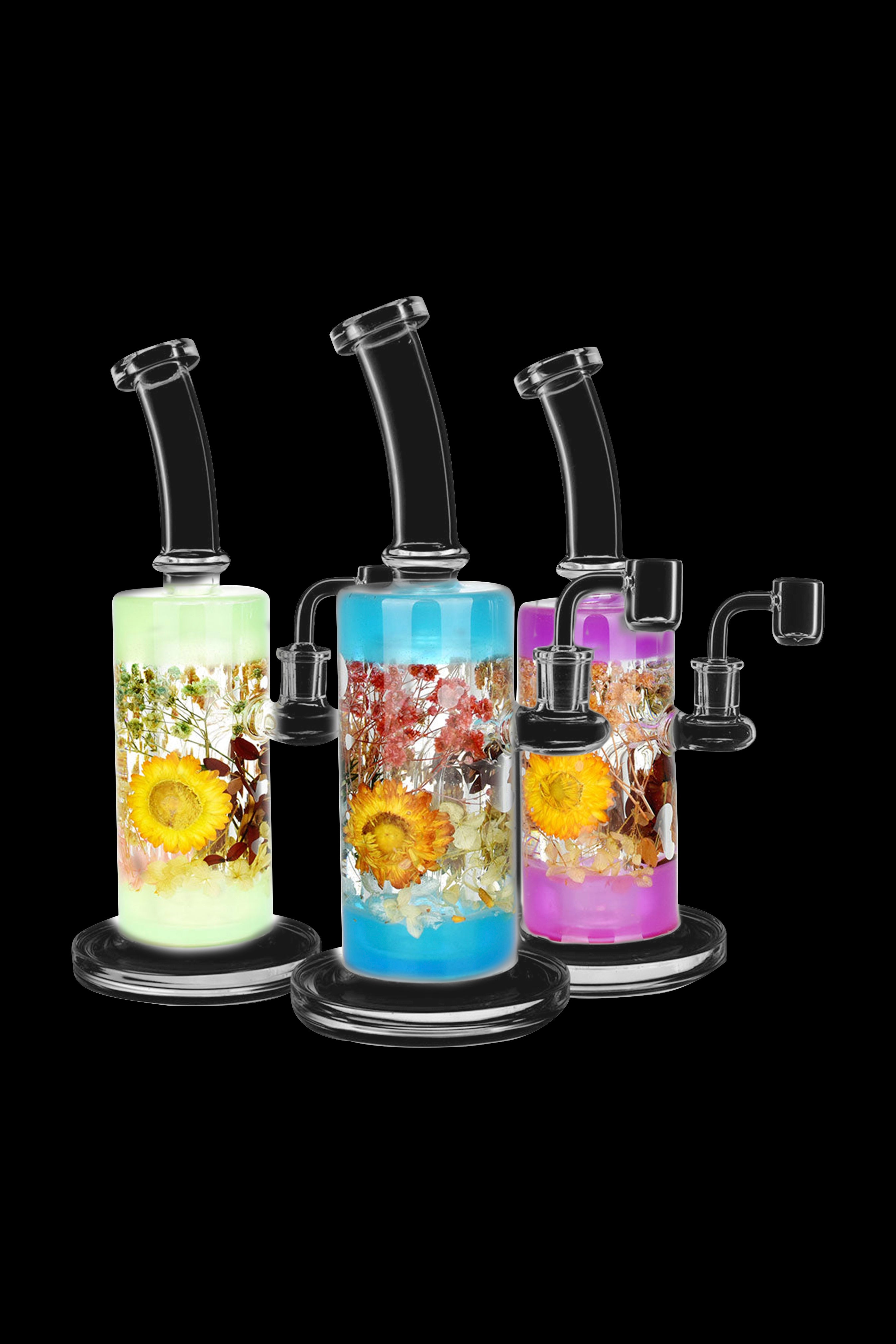 Assorted glass bongs with colorful floral designs, displayed against a black background.