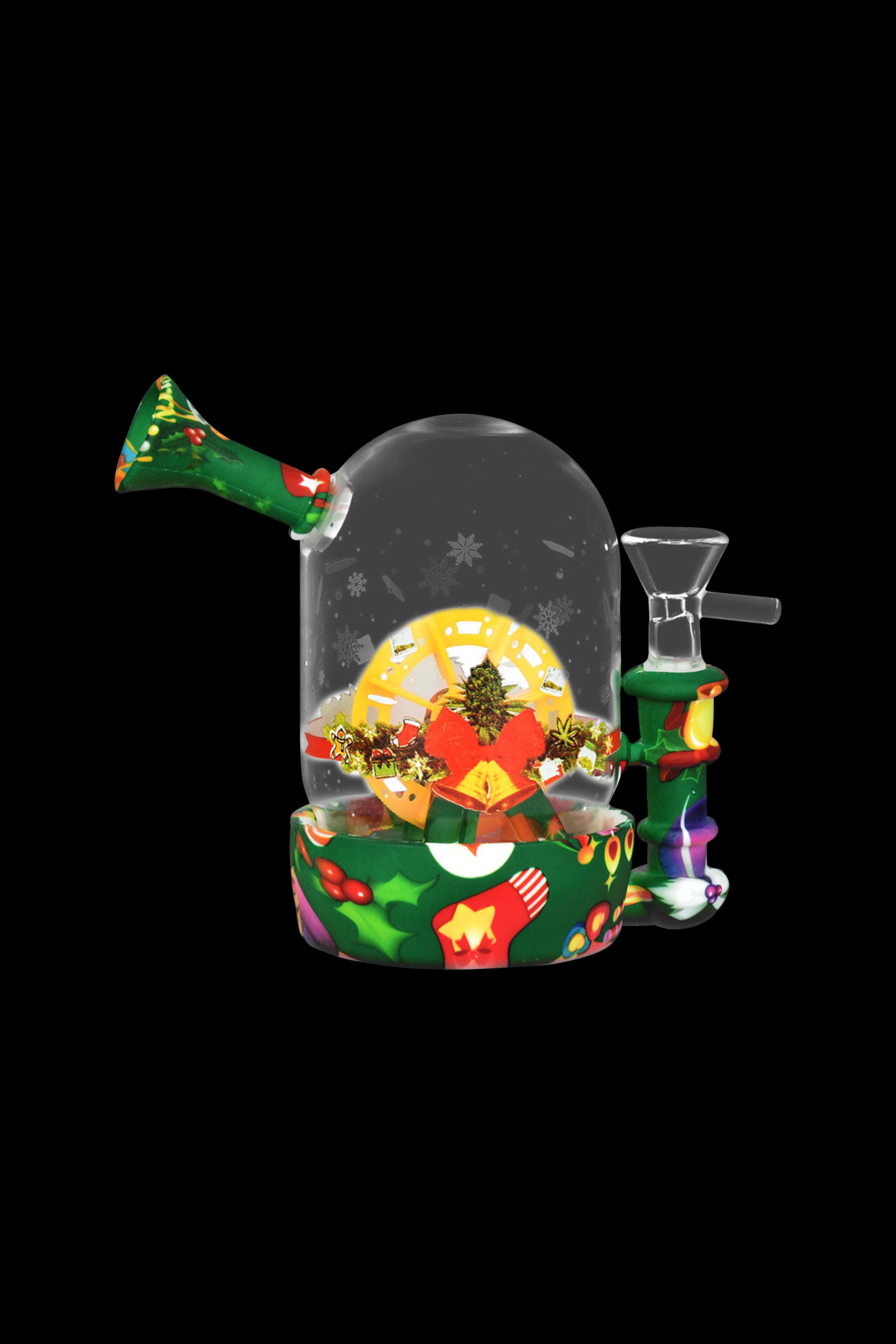 A festive glass snow globe water pipe with a Christmas tree and gifts inside, set against a black background.