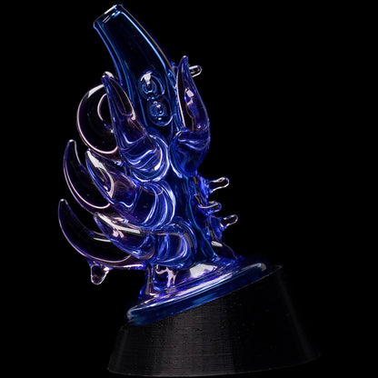 Angled close-up of a blue Glassic Cosmic Tentacle Puffco Peak Glass Attachment with curling, glossy glass tentacles against a black background