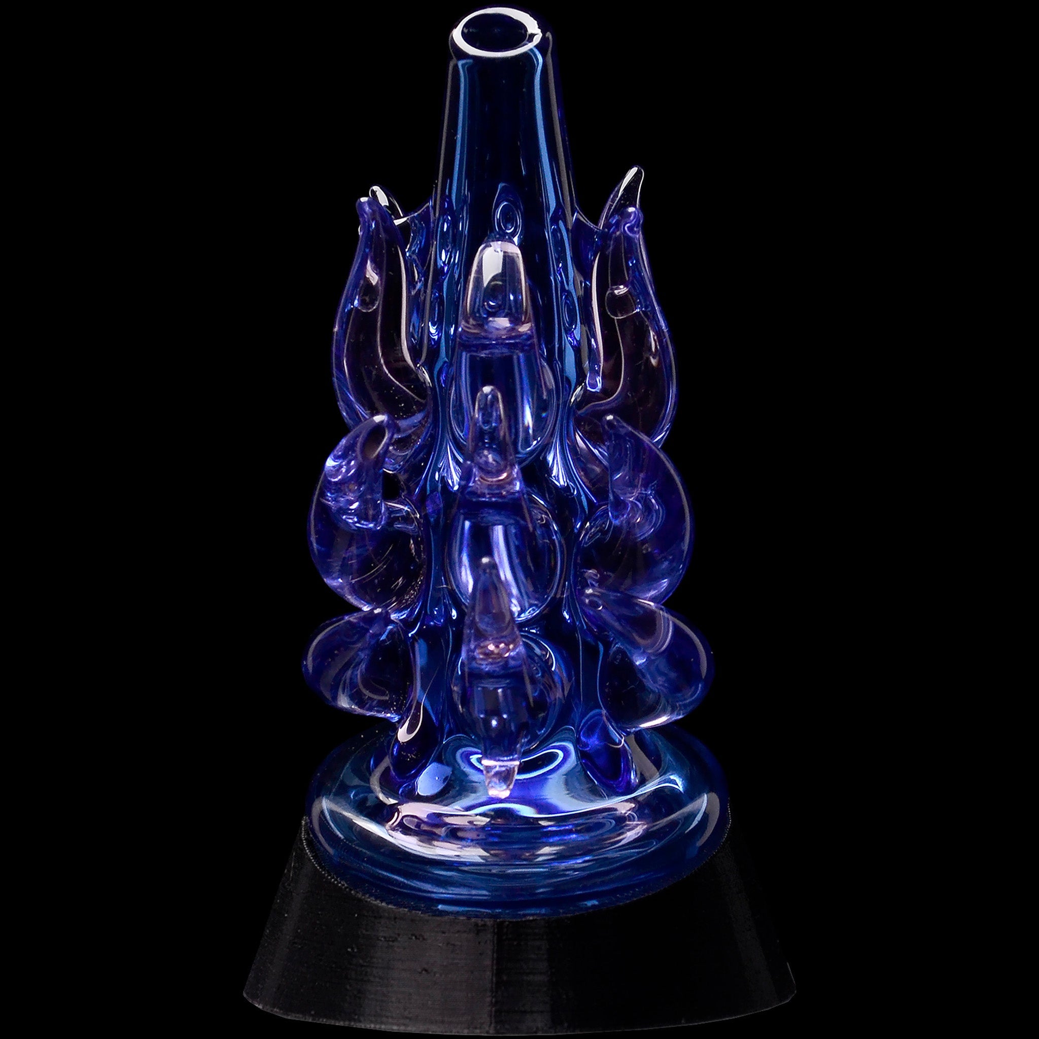 Close-up front view of the Glassic Cosmic Tentacle Puffco Peak Glass Attachment in translucent deep blue with curled glass tentacles against a black background