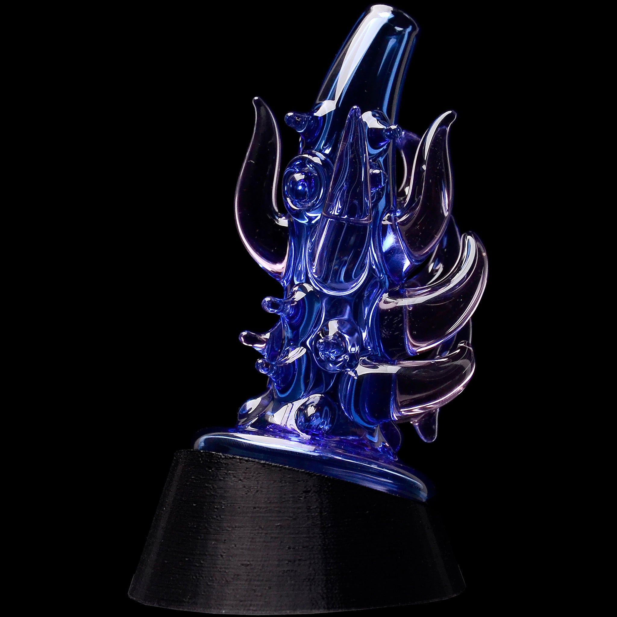 Close-up of the Glassic Cosmic Tentacle Puffco Peak Glass Attachment in dark blue, photographed at a slight angle against a black background.