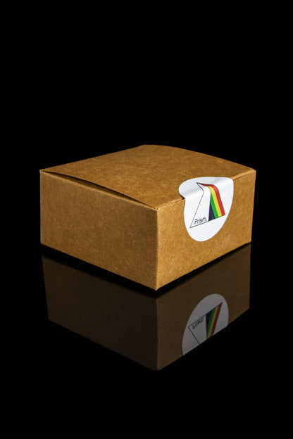 Brown cannabis packaging box with a rainbow Prism logo, reflected on a glossy surface.