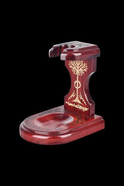 A dark red, intricately carved wooden pipe stand inspired by *The Lord of the Rings*, featuring a White Tree of Gondor design, with a circular base and holder for a pipe.