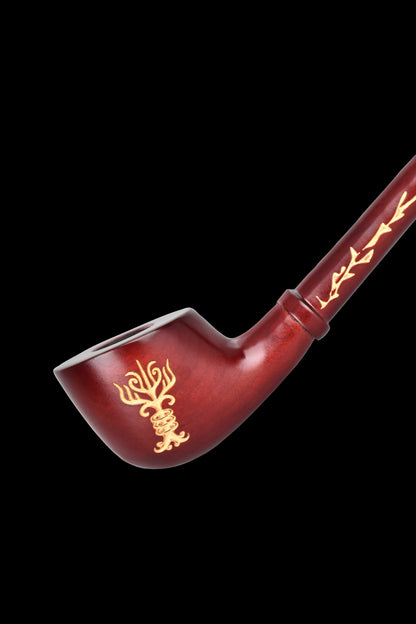 Red glass pipe with gold floral and geometric designs, isolated on a black background.