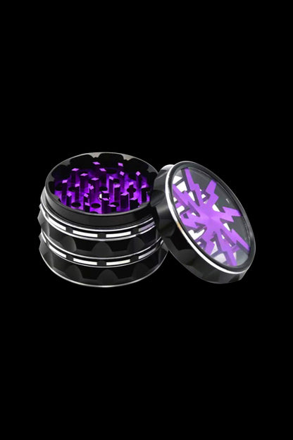 Black and silver cannabis grinder filled with purple flower, open to show ground material.