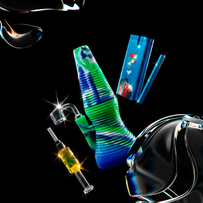 Angled close-up of a blue-and-green Smoke Cartel Rigid Silicone Mini Dab Rig against a black background with shiny sparkles.