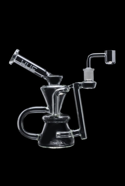 Angled side view of the clear 7.5" Hue - Hourglass Dab Rig Clear showing its hourglass chambers, curved handle, and upright banger against a black background