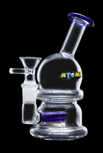 Clear glass bubbler with blue accents and "ATOMIC" lettering, used for smoking cannabis.