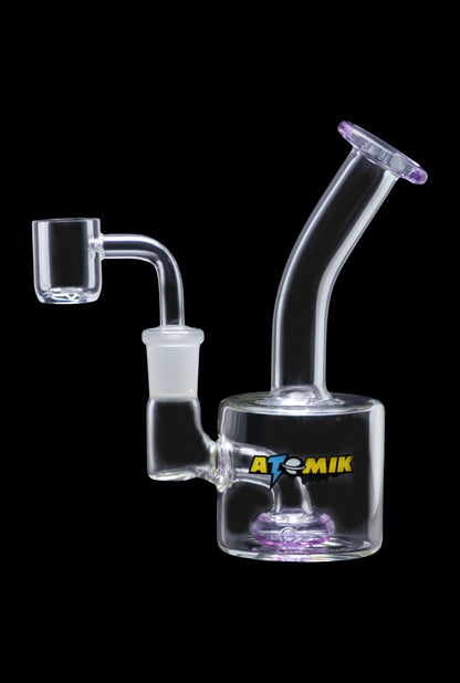 A side view of the Atomik Little Dipper Dab Rig showing the clear glass construction and angled neck.