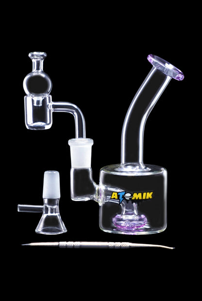 A side view of the Atomik Little Dipper Dab Rig, showcasing its clear glass construction and compact 5.25-inch size.