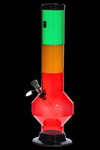 Straight-on view of the colorful JM Plastics Rasta Geometric with Pull Slide Acrylic Bong showing stacked green, yellow and red chambers against a black background.