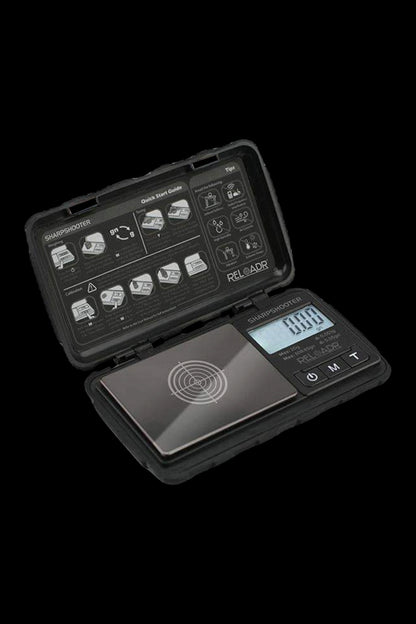 Digital scale with open case displaying quick start guide, likely for measuring cannabis.