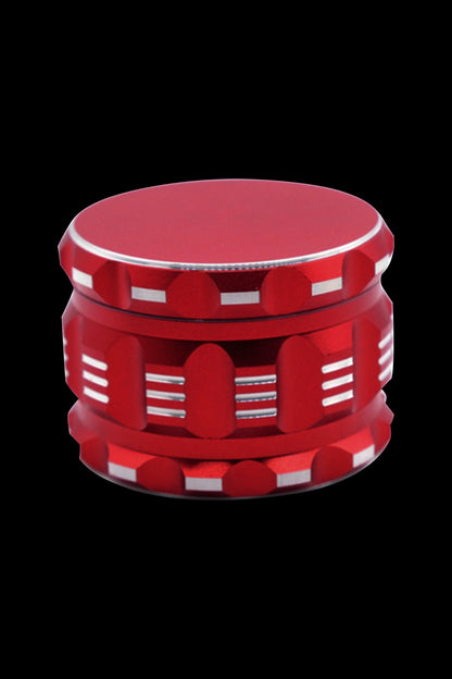 Red cannabis grinder with a casino chip design.
