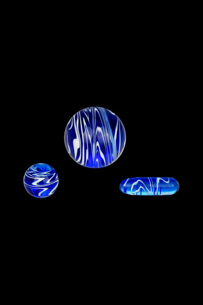 Blue and white marbled glass pieces, likely cannabis accessories, against a black background.