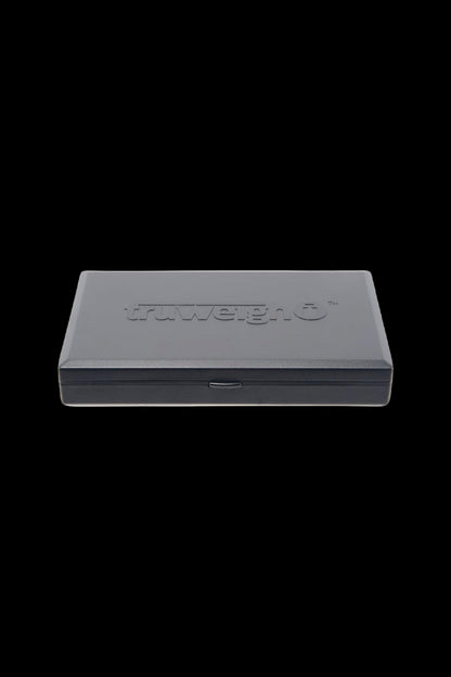 Low-angle front view of the Truweigh Grand Classic Digital Scale - 200g x 0.01g closed in its textured gray plastic case against a black background