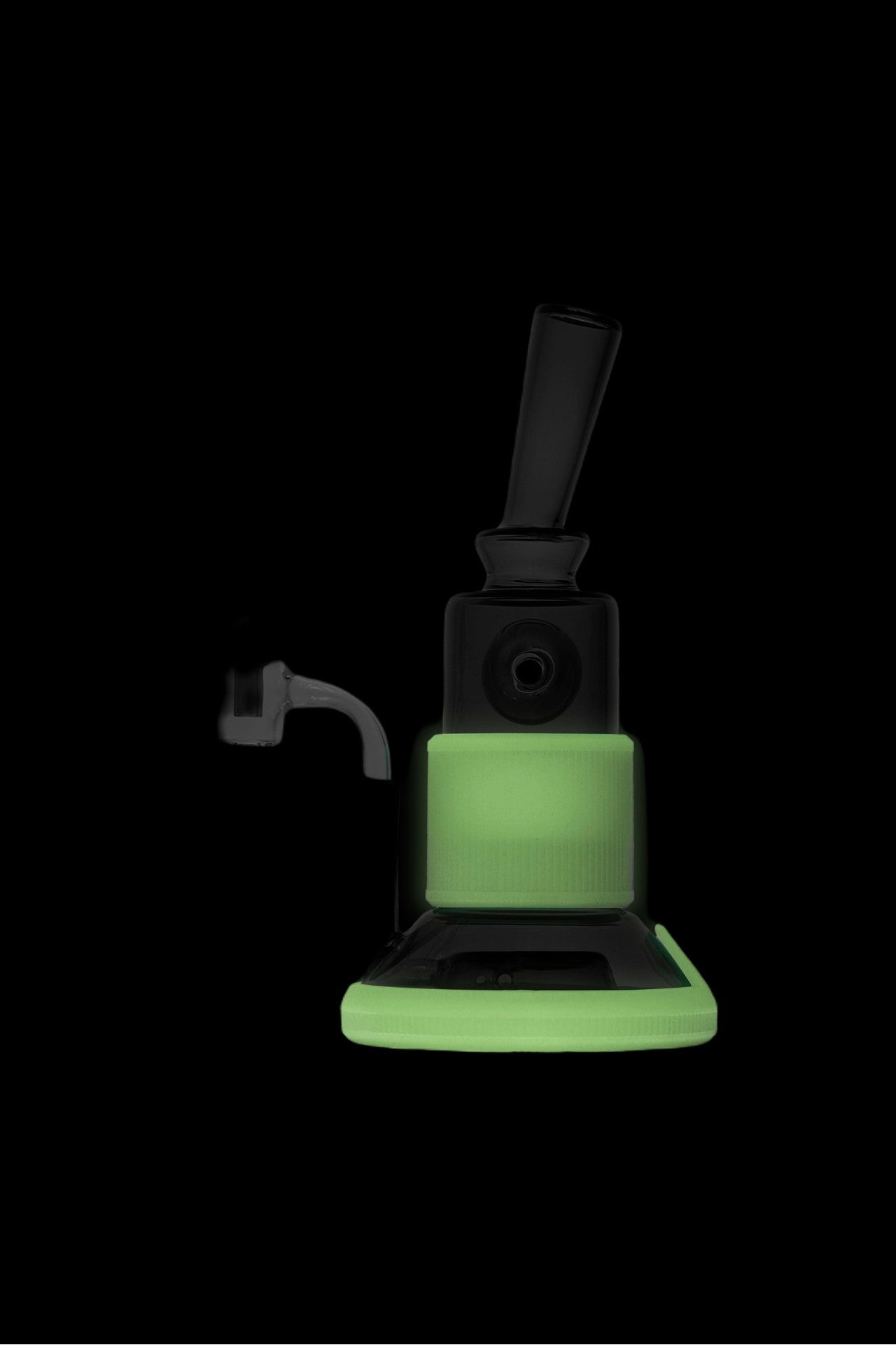Glowing cannabis dab rig with carb cap and glass attachment on black background.