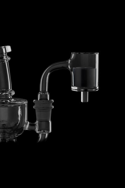 Dark glass dab rigs and accessories against a black background.