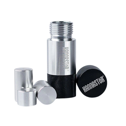 Close-up of a disassembled silver and black RYOT Kannastor Kief Press Pollen showing the threaded main cylinder, textured base, loose caps, and a black end cap branded "KANNASTÖR".