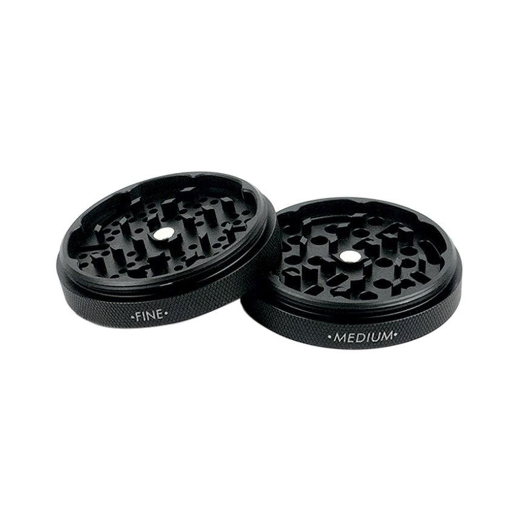 Angled close-up of two rose gold RYOT GR8TR Jar Body Grinder halves with textured rims and labeled "FINE" and "MEDIUM" faces on a white background