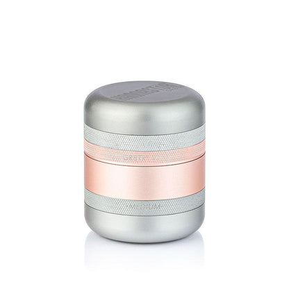 Front-facing studio shot of the metallic RYOT GR8TR Solid Body Grinder with silver and rose-gold stacked bands on a white background