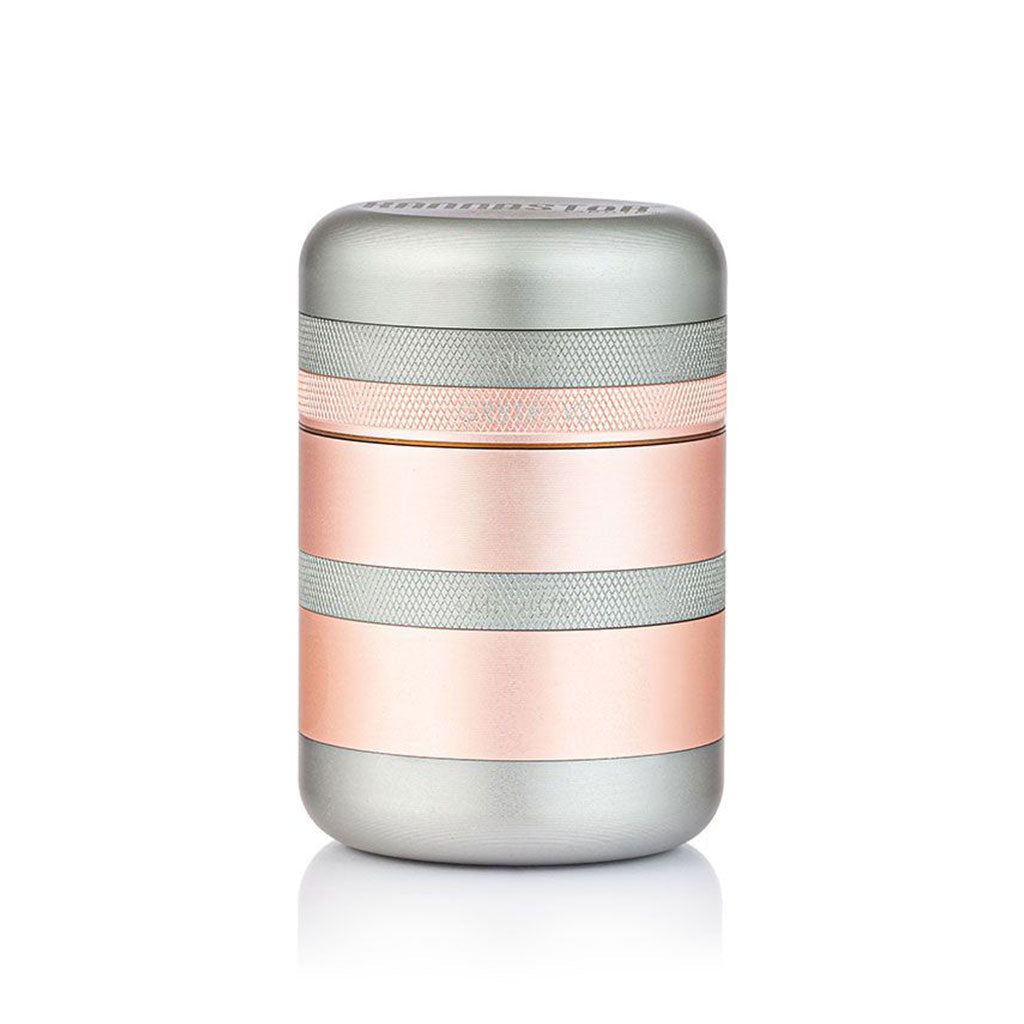 Centered front view of the metallic RYOT GR8TR Solid Body Grinder in silver and rose-gold bands against a white background.