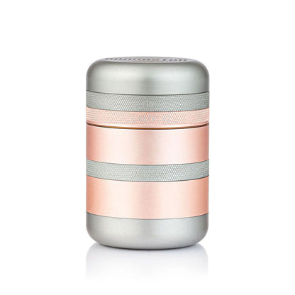Centered front view of the metallic RYOT GR8TR Solid Body Grinder in silver and rose-gold bands against a white background.