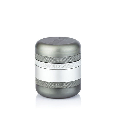 Centered front view of the RYOT GR8TR Solid Body Grinder in metallic rose-gold tones, shown on a white background with soft shadow.
