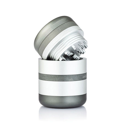 Angled close-up of the RYOT GR8TR Solid Body Grinder with its silver top lifted to reveal staggered metal teeth inside.