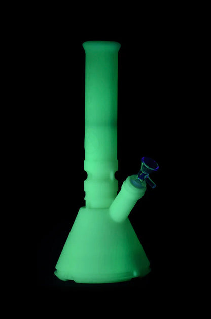 Glowing green glass bong isolated on black.