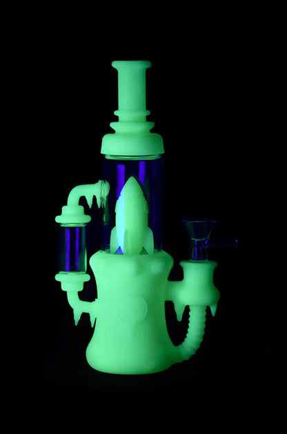 Glowing green glass water pipe (rig) with purple accents against a black background.