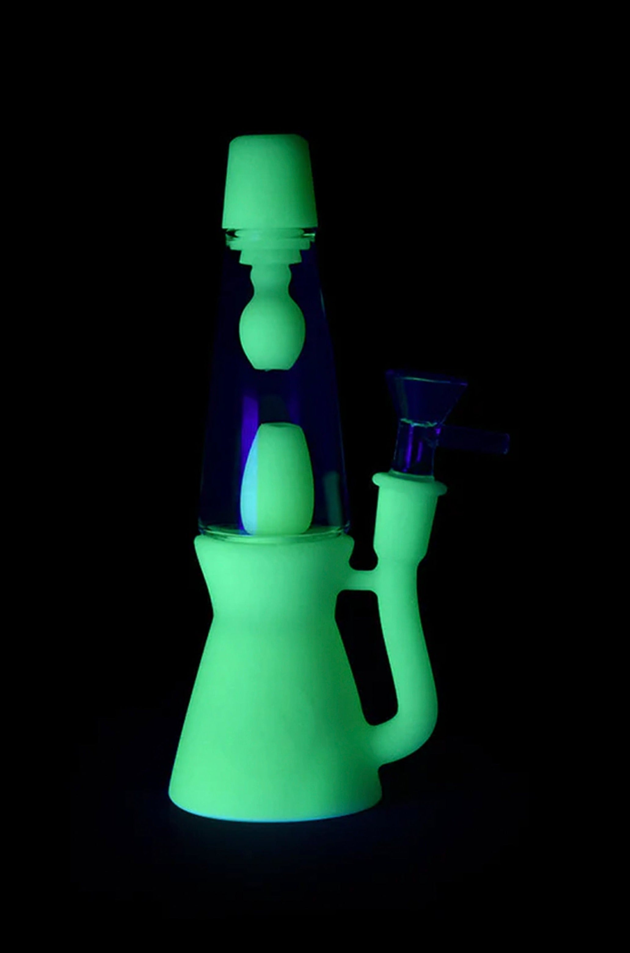 Glowing green and purple glass water pipe against a black background.