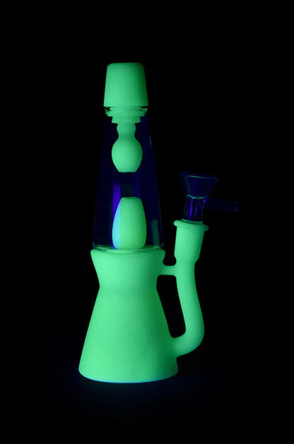 Glowing green and purple glass water pipe against a black background.