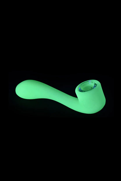 Glowing green glass pipe isolated on a black background.