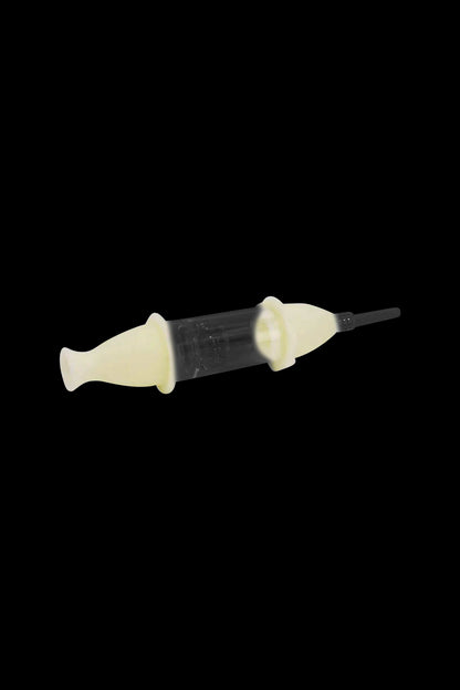 Yellow and clear cannabis oil applicator syringe on a black background.