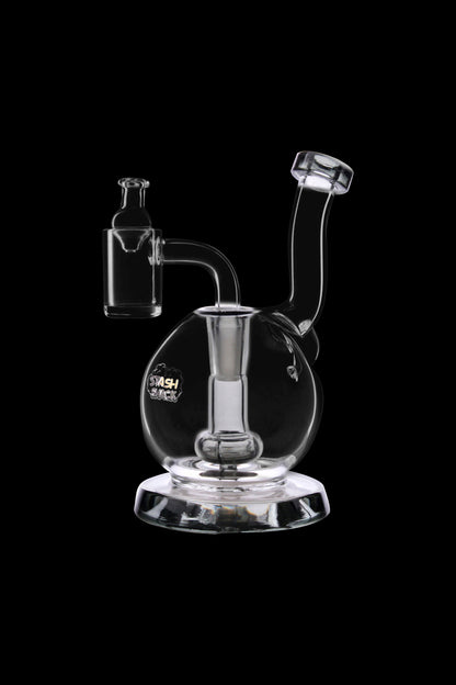 Clear glass dab rig with a bubbler and quartz nail, isolated on a black background.