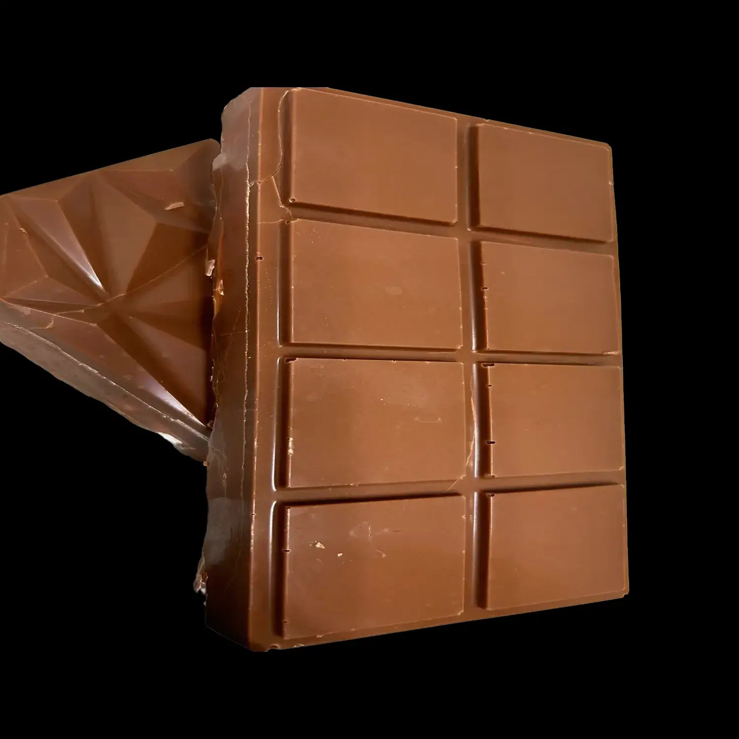 Chocolate bar divided into eight squares, partially unwrapped, against a black background.
