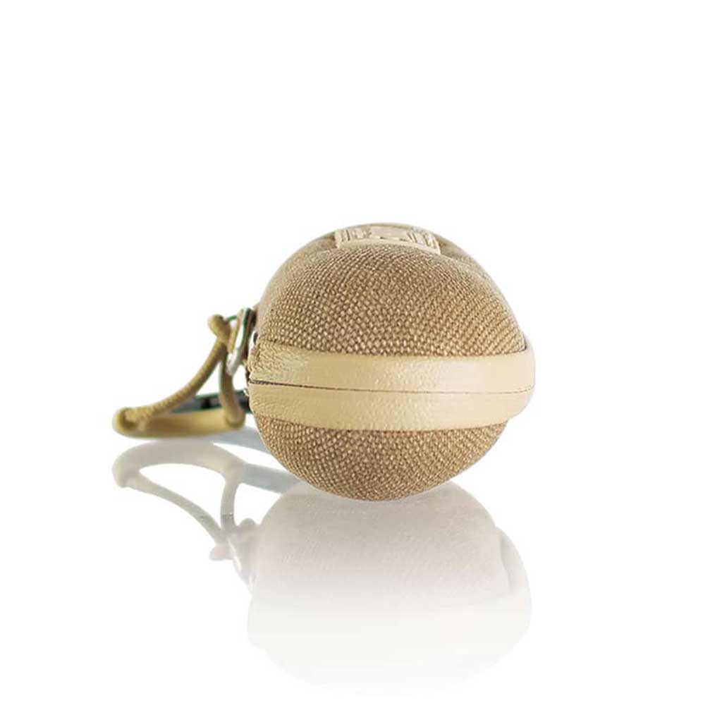 Front-facing close-up of a tan textured RYOT Hardcase keychain capsule resting on a reflective white surface.