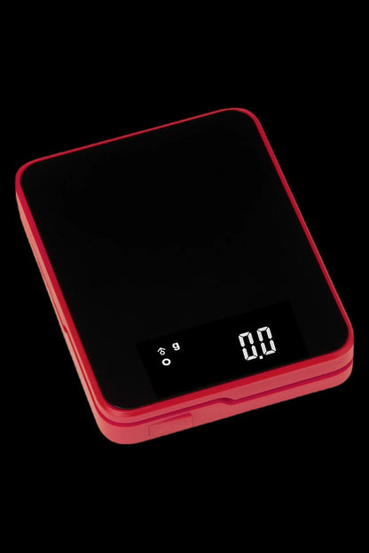 Red digital scale displaying 0.00 grams, used for measuring cannabis.