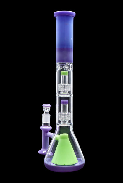 A vibrant, multi-chambered glass water pipe (bong) with purple and green accents, displayed with a separate glass piece.