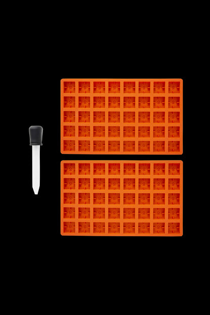 Cannabis concentrate collection tool and silicone dab tray on a black background.